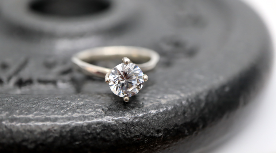 Solitaire Engagement Ring resting on a weight